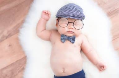 Baby wearing trendy eyeglasses and a hat
