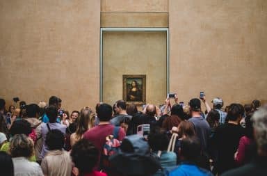 mona lisa, by da vinci, and surrounded by people, why is she smiling? history's mystery i guess