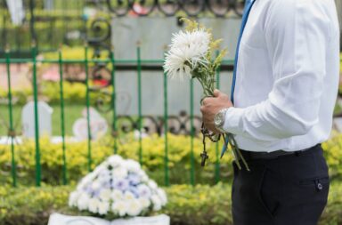 holding flowers graveside
