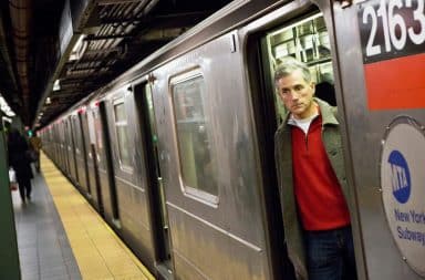 Man looking out of a subway car suspiciously