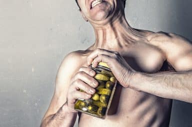 man opening a jar of pickles