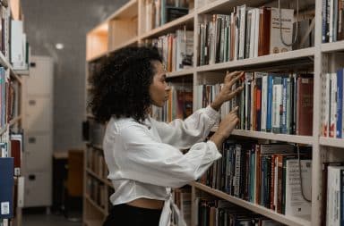 woman picking a book from the library